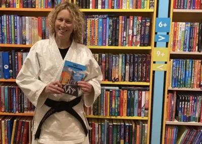 Charlotte Doornhein in haar jiu-jitsu pak met zwarte band in boekhandel.